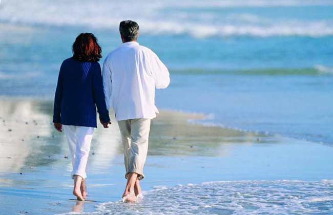 Two people walking along the shore.
