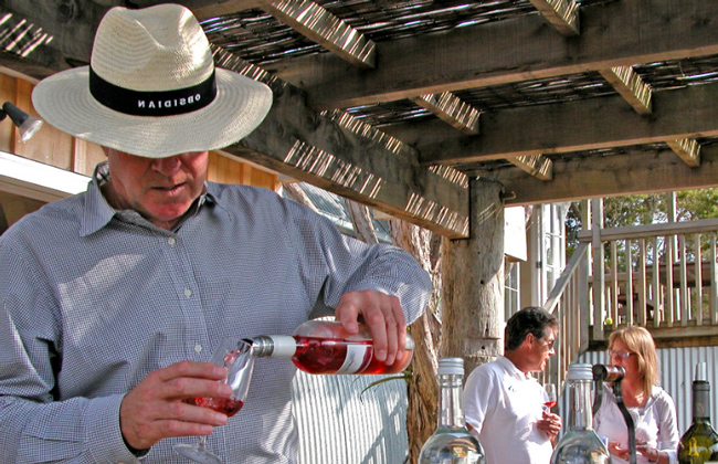 A person filling a glass of wine.