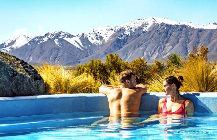 Relax in the hot pools at Tekapo with mountains to gaze upon.