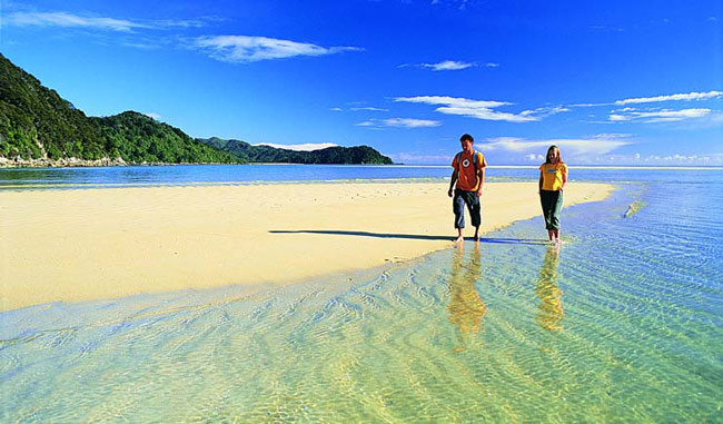 Couple walking on Abel Tasman beach