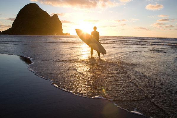 Surfing the black sands of Piha