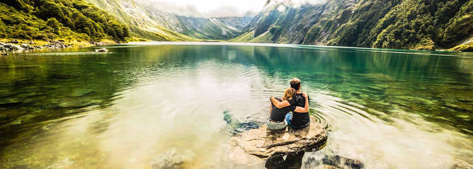 Honeymoon couple enjoying the solitude of a remote South Island Lake in New Zealand