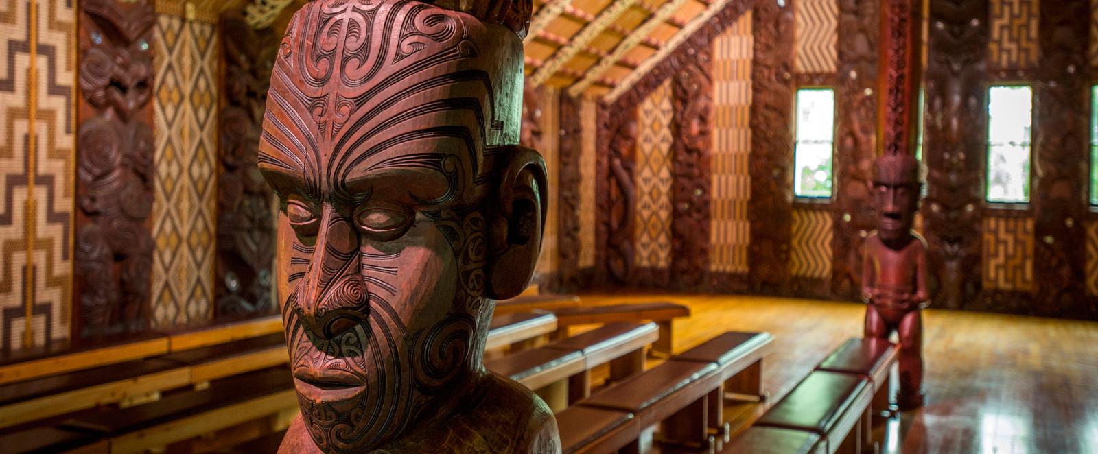A couple examining the intricate carvings at the Waitangi marae (meeting grounds)