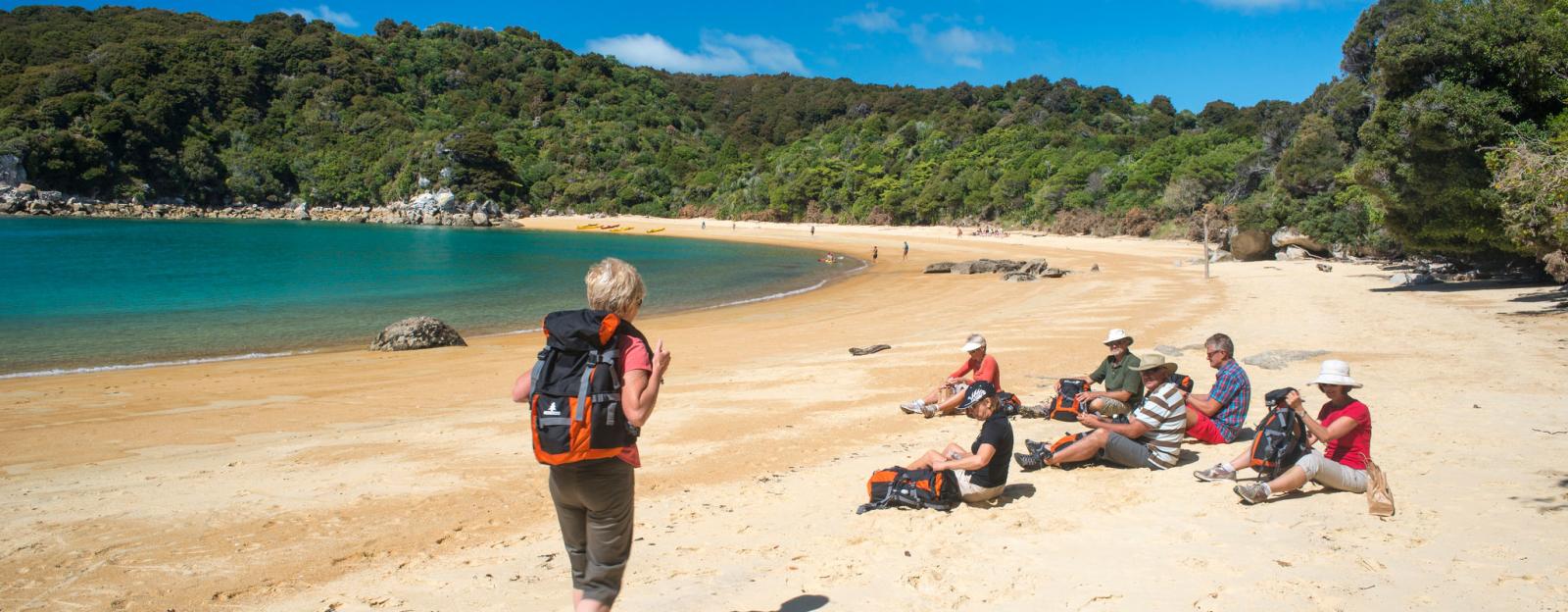 Woman strolling along the golden sands of Abel Tasman National park.