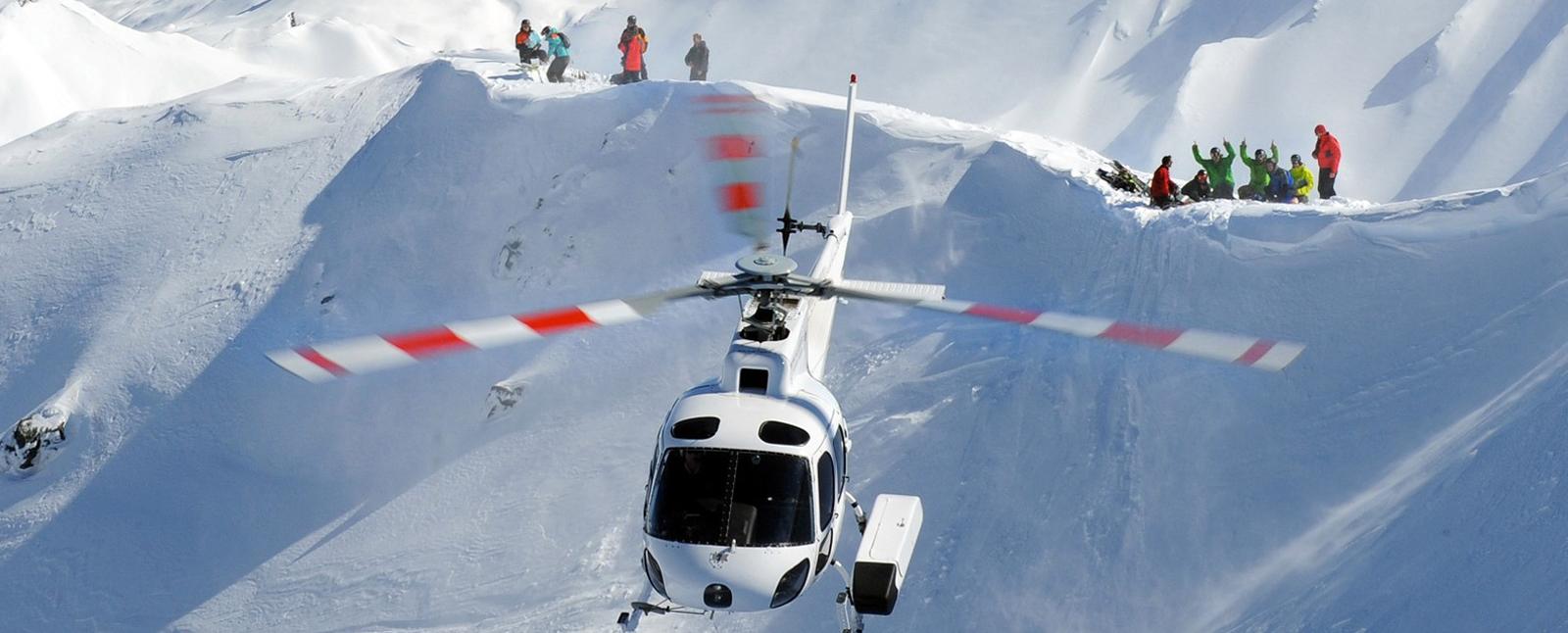 Group of you skiers being dropped off by a helicopter in the Methvan mountains.