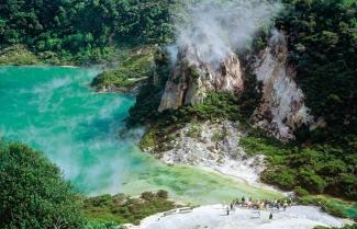 Aerial view of geothermal lake with steam rising