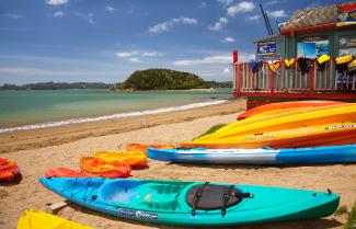 Kayaks sitting on Paihia beach.