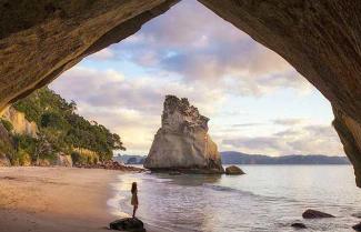 Girl standing in the massive Cathedral Cove.